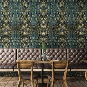 May include: A restaurant interior with a long brown leather bench with tufted upholstery. The wall behind the bench is covered in a green and gold patterned wallpaper. There are wooden chairs and tables in front of the bench.