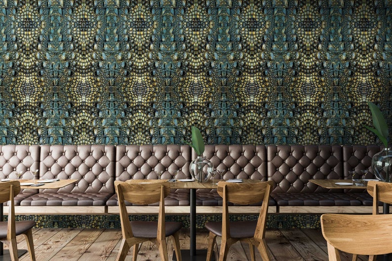 May include: A restaurant interior with a long brown leather bench with tufted upholstery. The wall behind the bench is covered in a green and gold patterned wallpaper. There are wooden chairs and tables in front of the bench.