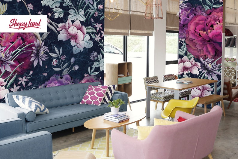 May include: A living room interior design with a blue sofa, pink armchair, and a wooden coffee table. The walls are decorated with a floral wallpaper featuring pink and purple flowers on a dark blue background. The text "Shoppy Land" is visible on the wall.