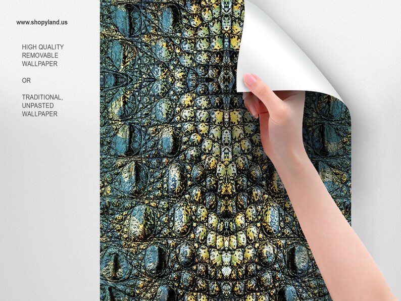 May include: A close-up of a crocodile skin wallpaper with a green, blue, and yellow color scheme. The wallpaper is being applied to a white wall.