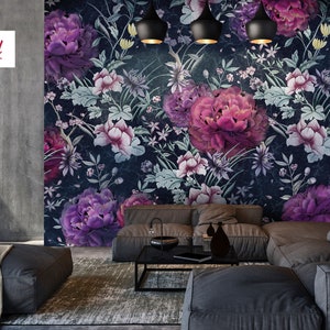 May include: A living room interior design featuring a dark blue floral wallpaper with pink and purple flowers. The wallpaper features a repeating pattern of flowers and leaves. The room is furnished with a gray sectional sofa and a black coffee table.
