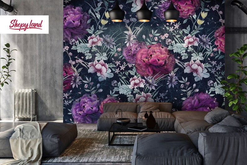 May include: A living room interior design featuring a dark blue floral wallpaper with pink and purple flowers. The wallpaper features a repeating pattern of flowers and leaves. The room is furnished with a gray sectional sofa and a black coffee table.