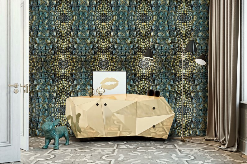 May include: A gold geometric console table with a mirrored finish sits in front of a wall covered in teal and gold crocodile skin patterned wallpaper. A teal blue ceramic dog figurine sits on the floor in front of the table.