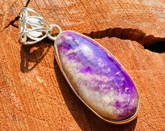 May include: A silver pendant with a purple and white fluorite stone. The stone is oval shaped and has a swirl pattern.