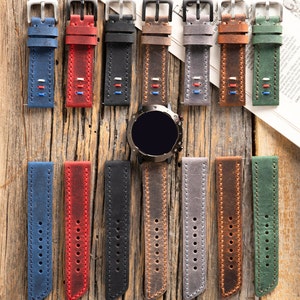 May include: A set of 10 leather watch bands in various colors, including blue, red, black, brown, gray, and green. The bands are all made of leather and have a stitched design. The bands are shown on a wooden surface.