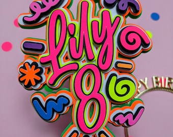 Könnte beinhalten: Ein farbenfroher Tortenaufsatz zum Geburtstag mit dem Namen "Lily" und der Zahl "8". Das Design zeigt geschichtete Elemente in Neonrosa, Grün, Orange und Blau. Der Aufsatz ist auf einem gestreiften Strohhalm befestigt. Konfetti ist verstreut.