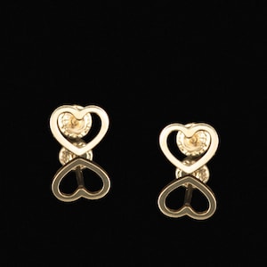 May include: A pair of gold heart-shaped earrings with a delicate open design. The earrings are small and dainty, perfect for everyday wear.