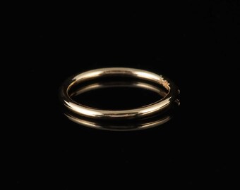 May include: A simple gold bangle bracelet, a classic piece of jewelry.