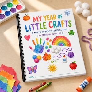 May include: A spiral-bound activity book titled My Year of Little Crafts: A Month-by-Month Keepsake Book, 24 Hands-on Activities. The cover features colourful watercolour illustrations of a pumpkin, heart, handprint, rainbow, leaf, butterfly, sun, apple, and glue bottle.