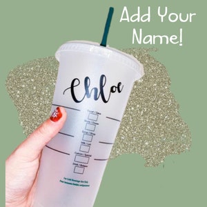 May include: A white reusable cup with a black lid and a green straw. The cup has a black design with the word "Chloe" written on it. The cup has markings for "Draft/Decaf", "Shots/Doses", "Syrup/Syrup", "Milk/Lat", "Custom/Special", and "Drink/Bolson". The text "Add Your Name!" is written in white on a green background.