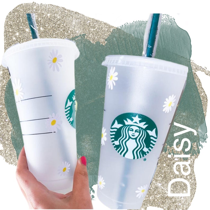 May include: Two clear plastic tumblers with white daisy designs. One tumbler has a green Starbucks logo with a mermaid and the other has a black and white striped design. Both tumblers have clear straws.