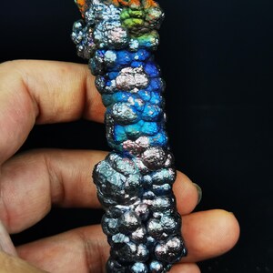 May include: A iridescent, metallic, blue, green, and orange, mineral specimen with a bubbly texture.