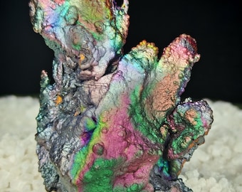 May include: A large, iridescent, multi-colored mineral specimen with a rough, textured surface. The mineral is a deep purple, green, and blue with hints of pink and orange.