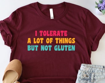 May include: A maroon t-shirt with the text "I tolerate a lot of things but not gluten" in colorful letters.