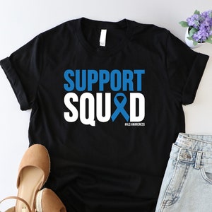 May include: Black t-shirt with white text that reads "SUPPORT SQUAD" with a blue ribbon and the words "BLUE AWARENESS" underneath.