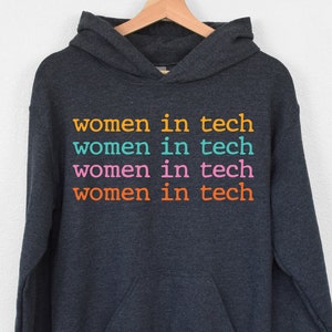 May include: A dark gray hooded sweatshirt with the text "women in tech" repeated four times in different colors: orange, teal, pink, and orange.