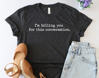 May include: A dark gray t-shirt with the text "I'm billing you for this conversation." printed in white.
