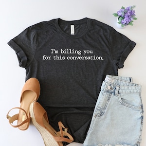 May include: A dark gray t-shirt with the text "I'm billing you for this conversation." printed in white.