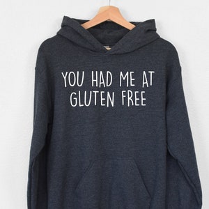 May include: A dark gray hooded sweatshirt with the text "You had me at gluten free" printed in white on the front.