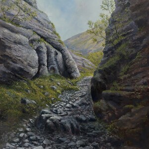 May include: A rocky path winds through a narrow canyon with steep, gray rock walls. The path is covered in small stones and leads to a distant, green hillside.