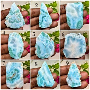 May include: A collection of nine polished Larimar stone slabs, each numbered one through nine, displaying unique patterns of sky blue, turquoise, and white marbling with organic, irregular shapes and smooth, flat surfaces for display.