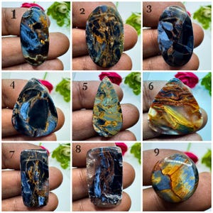 May include: A collection of nine polished gemstones featuring varied shapes including ovals, teardrops, and a circle. The stones display intricate patterns of deep blue, black, and golden-brown veining throughout their surfaces, each numbered one through nine.