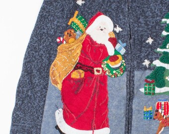 May include: A blue Christmas sweater with a zipper closure. The sweater features an appliqué of Santa Claus carrying a sack of toys, a Christmas tree, and a rocking horse. The sweater has a textured knit design.