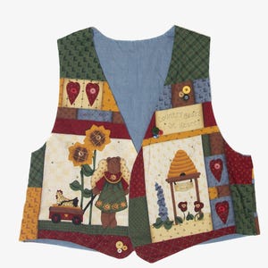 Könnte beinhalten: Gesteppte Weste mit Patchwork-Design. Mit Sonnenblumen, einem Bären, einem Huhn in einem Wagen und einem Bienenstock. Die Weste hat einen blauen Rücken und ist mit Knöpfen und dem Text "Country Bears at Heart" verziert.