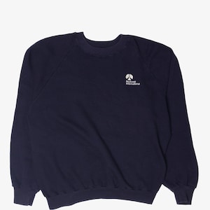 Op de afbeelding: Marineblauw sweatshirt met het witte "Rockwell International" logo op de borst. Het heeft een ronde hals, lange mouwen en geribde manchetten en zoom. Het sweatshirt is gemaakt van zacht materiaal en heeft een klassieke stijl.