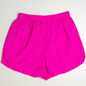 May include: Bright pink athletic shorts with an elastic waistband. The shorts are made of a lightweight material and have a relaxed fit. The shorts are designed for running or other athletic activities.