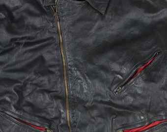 May include: Black leather jacket with a notched collar, asymmetrical zipper, and multiple zippered pockets. The jacket has a red lining visible in the pockets and a label that reads "Radar".