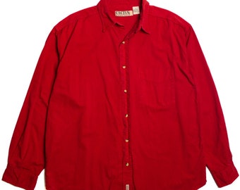 May include: A vibrant red button-down shirt with long sleeves. The shirt features a chest pocket and a collar. The brand name "CACTUS" is visible on the collar. The shirt is made of a soft, likely cotton, material.