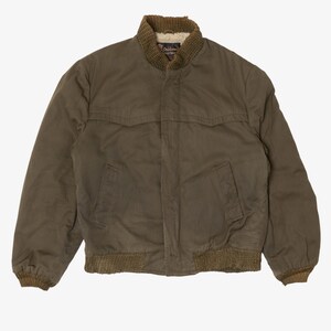May include: An olive green bomber jacket featuring a ribbed knit collar and hem in a darker olive tone. The jacket includes a front zip fastening, two side pockets, and a cream-coloured faux shearling lining visible at the inner collar area.