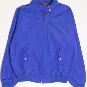 Puede incluir: Una chaqueta bomber azul con cierre de cremallera y dos bolsillos. La chaqueta tiene un cuello, puños y dobladillo de canalé.