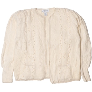 May include: A cream-colored knitted cardigan with a cable knit pattern and a delicate lace design. The cardigan has a button-up front and long sleeves.