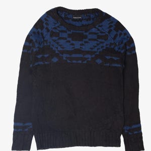 May include: Black knitted sweater featuring a blue geometric design across the upper chest and shoulders. The long-sleeved sweater has ribbed cuffs and hem. The blue pattern is repeated on the cuffs. The sweater is made of a soft, knitted material.