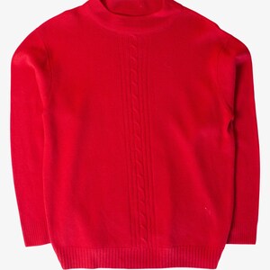 May include: A vibrant red long-sleeve sweater featuring a mock neck collar and a vertical cable knit pattern running down the center of the chest. The garment has ribbed cuffs and a ribbed hem, providing a structured fit with a solid color finish.