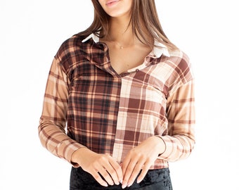 May include: A long-sleeved plaid shirt in shades of brown and tan, with a white collar. The shirt is paired with black velvet trousers. The top has a split design, with one side a darker brown plaid and the other a lighter tan plaid.