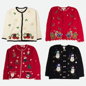 Op de afbeelding: Vier vesten met lange mouwen en knoopsluiting met vakantiethema's. Een cr&egrave;mekleurig vest met cadeautjes, een rood vest met peperkoekmannetjes, een rood vest met diverse seizoensiconen en een zwart vest met sneeuwpoppen die op ski's staan.
