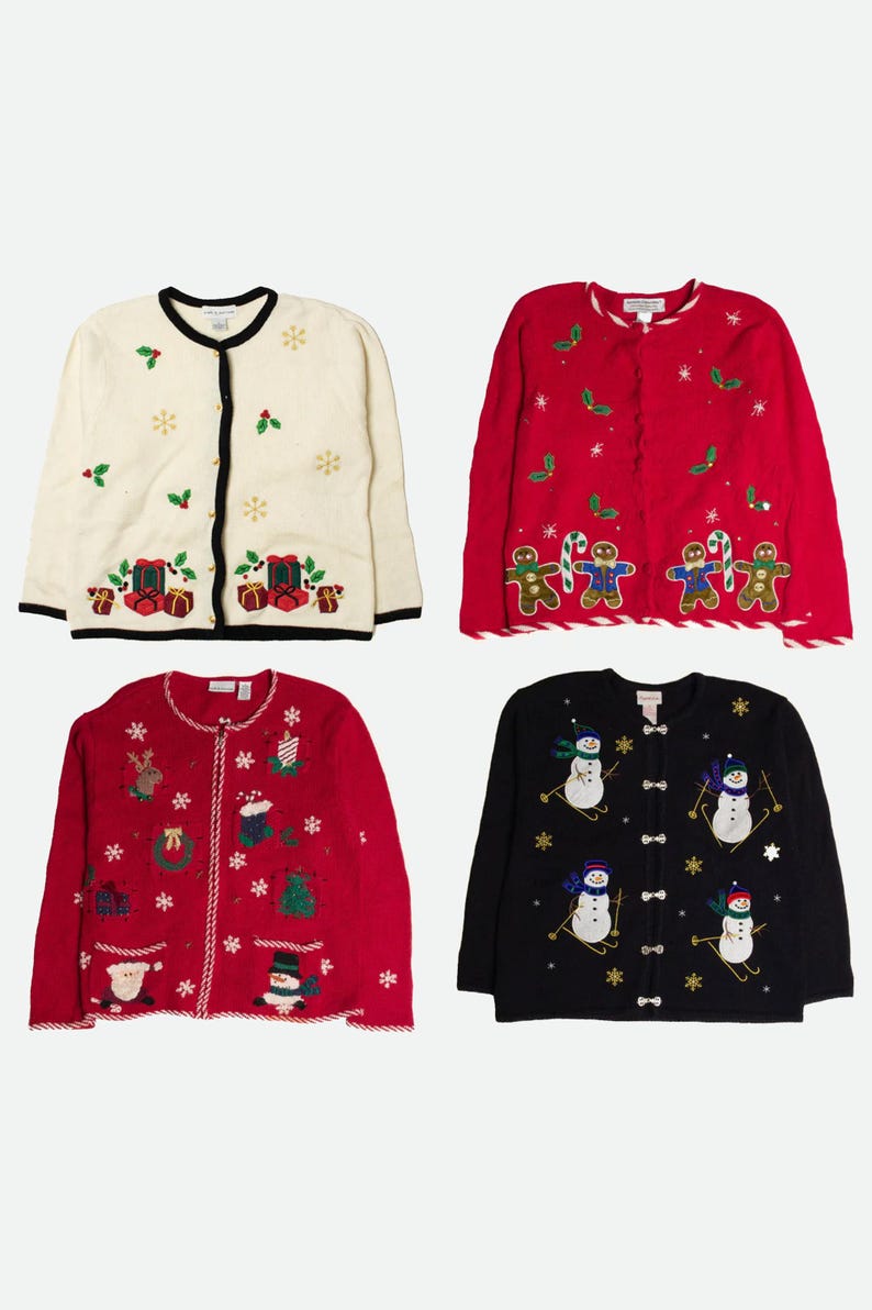 Op de afbeelding: Vier vesten met lange mouwen en knoopsluiting met vakantiethema's. Een cr&egrave;mekleurig vest met cadeautjes, een rood vest met peperkoekmannetjes, een rood vest met diverse seizoensiconen en een zwart vest met sneeuwpoppen die op ski's staan.