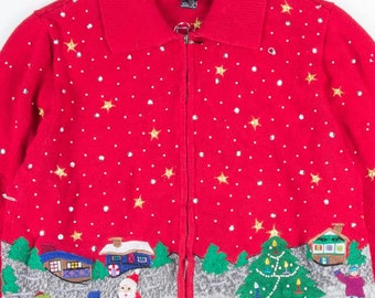 May include: Red zip-up Christmas sweater with a festive design. The sweater features a pattern of white stars and silver sequins. The bottom of the sweater has an embroidered winter scene with Santa Claus, a snowman, and children playing near a Christmas tree.