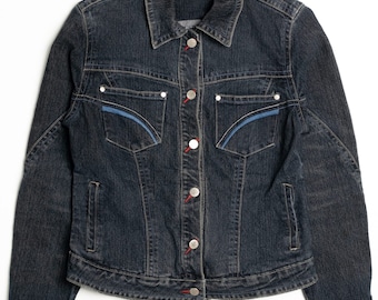 May include: A dark blue denim jacket with red stitching and a blue trim on the pockets. The jacket has a button closure and a Snazzie label on the collar.