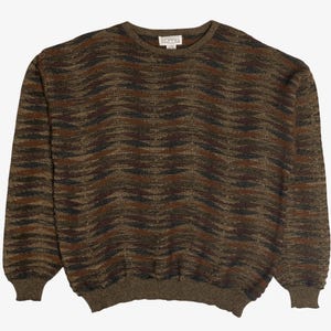 Könnte beinhalten: Ein braun, schwarz und olivgrün gemusterter Pullover mit Rundhalsausschnitt und langen Ärmeln. Der Pullover hat einen gerippten Saum und Bündchen. Das Etikett auf der Rückseite des Kragens lautet "BUFFALO".