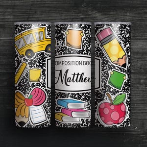 May include: A personalised tumbler with a composition book design and school-themed stickers. The design includes a yellow school bus, pencil, apple, and the name "Matthew". The tumbler is decorated with a black and white speckled pattern.