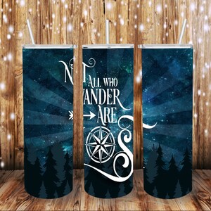 May include: Three tall, insulated tumblers with white straws. The tumblers feature a dark blue starry night design with white text that reads "Not all who wander are lost" and a compass graphic. A forest silhouette is at the bottom.