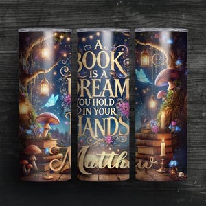 May include: A stainless steel tumbler with a whimsical forest scene and the quote "A book is a dream you hold in your hands". The tumbler has a personalized name, "Matthew", on the bottom.