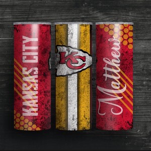 May include: Three red and gold stainless steel tumblers with a distressed look. The center tumbler features the Kansas City Chiefs logo. The tumbler on the left says "Kansas City" and the tumbler on the right says "Matthews".