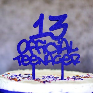 Könnte beinhalten: Ein weißer Kuchen mit blauen Streuseln und einem blauen Kuchentopper mit der Aufschrift "13 Official Teenager".