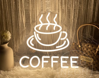 May include: White neon sign with a coffee cup and steam design. The sign reads "COFFEE" in a bold font.