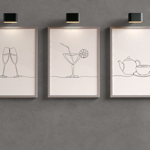 May include: Three framed black and white line drawings on a gray wall. The first drawing shows two champagne flutes, the second drawing shows a cocktail with a straw and a lemon wedge, and the third drawing shows a teapot and a cup.